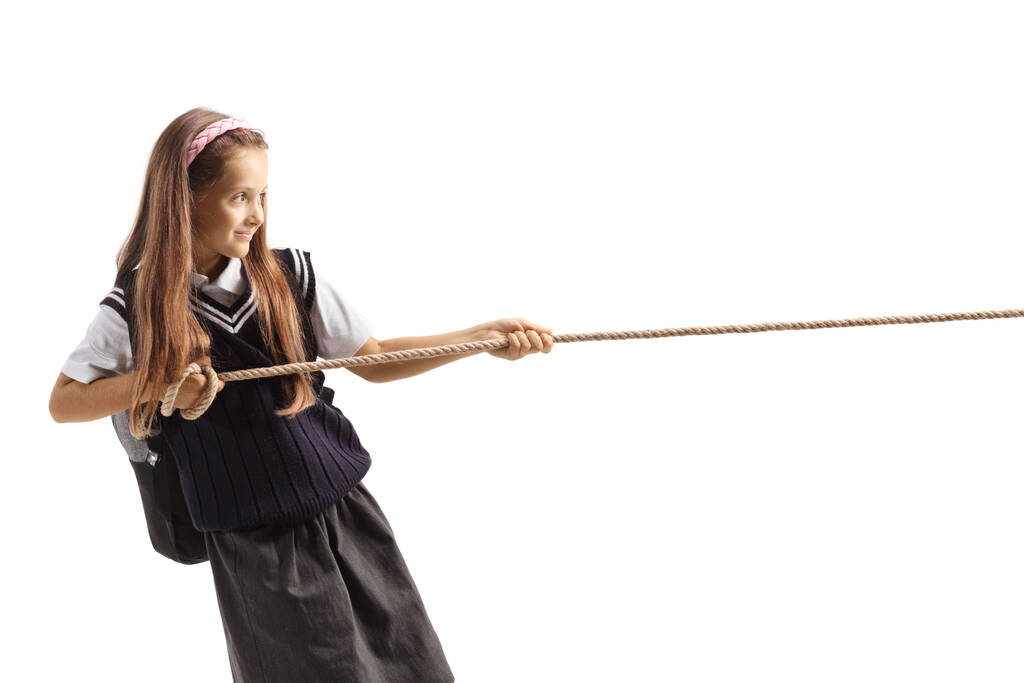 Schoolgirl pulling a rope isolated on white background - Photo, Image