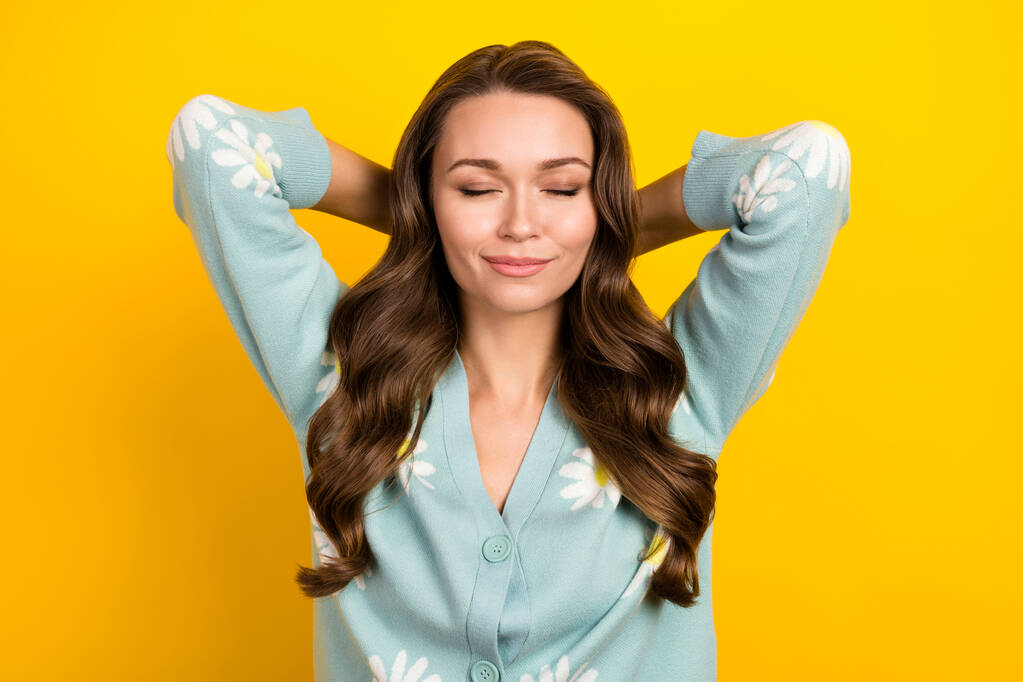 Photo of cheerful dreamy woman wear turquoise cardigan arms behind head closed eyes isolated yellow color background. - Photo, Image