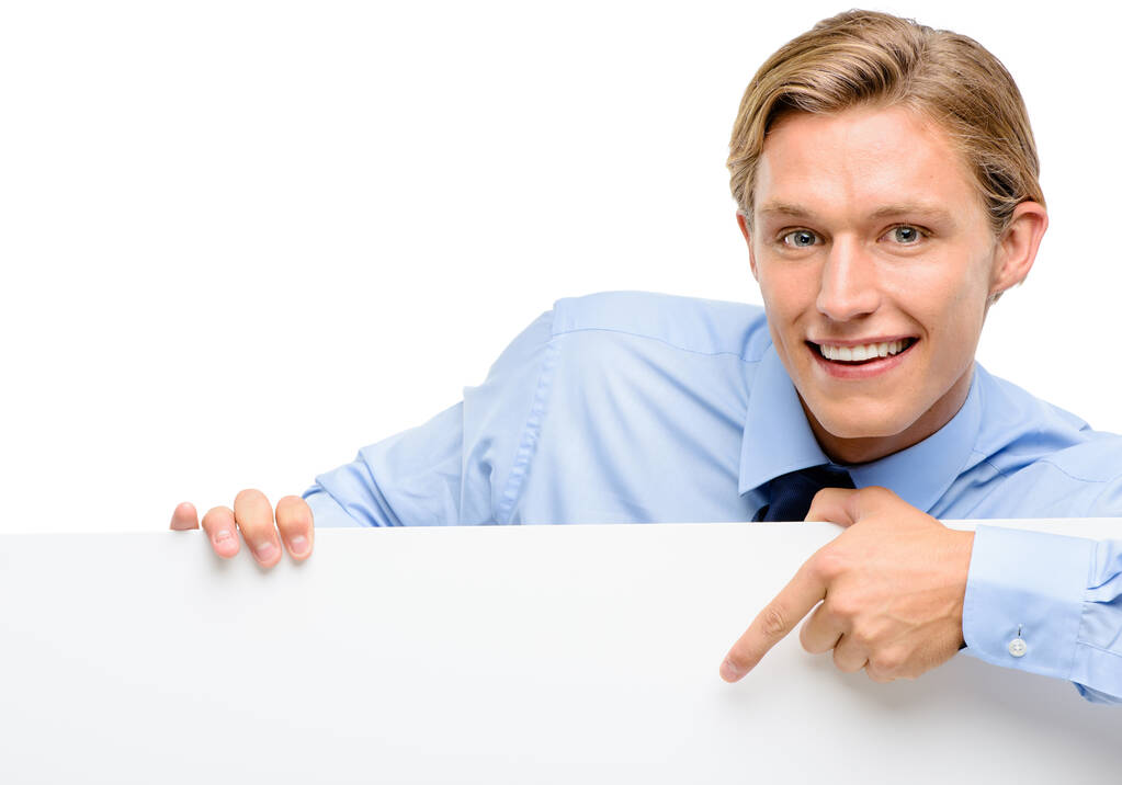 Just sign up here. a handsome young businessman standing alone in the studio and pointing at a promotion - Photo, Image