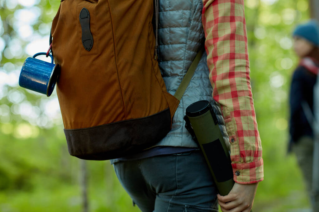 Randonnée pédestre avec une amie à travers les bois dans une vue rapprochée sur son sac à dos et son équipement par derrière - Photo, image