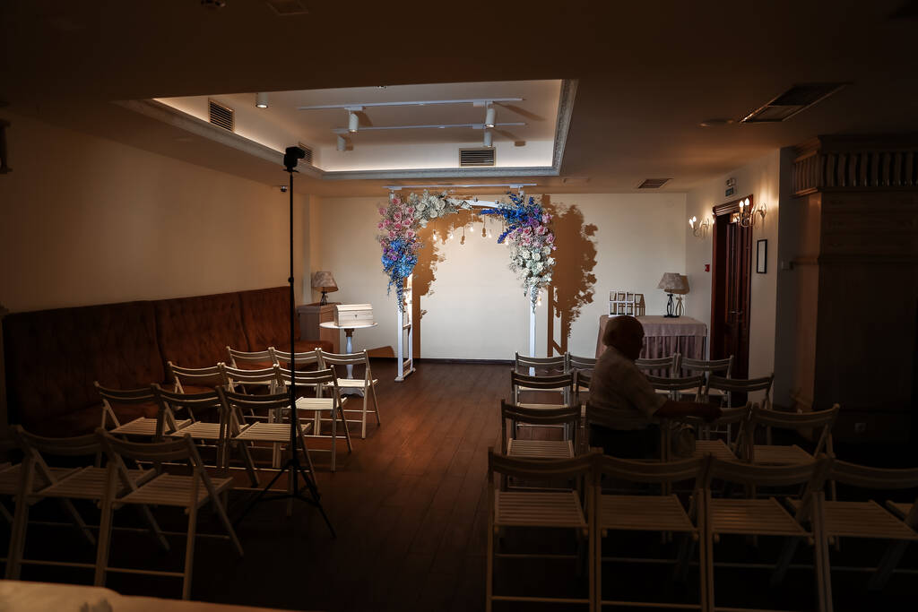 Ceremonia de boda interior con arco de boda blanco decorado con flores y grandes velas blancas. Foto de alta calidad - Foto, imagen