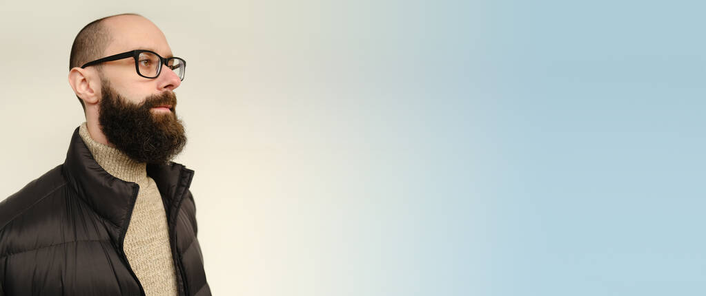close-up mannelijk gezicht, jonge pensive bebaarde en snor man, tevreden man met 30 jaar in zwart jasje, bril serieus kijkt weg, concept van de menselijke gezondheid, kopieer ruimte banner en plaats voor tekst - Foto, afbeelding