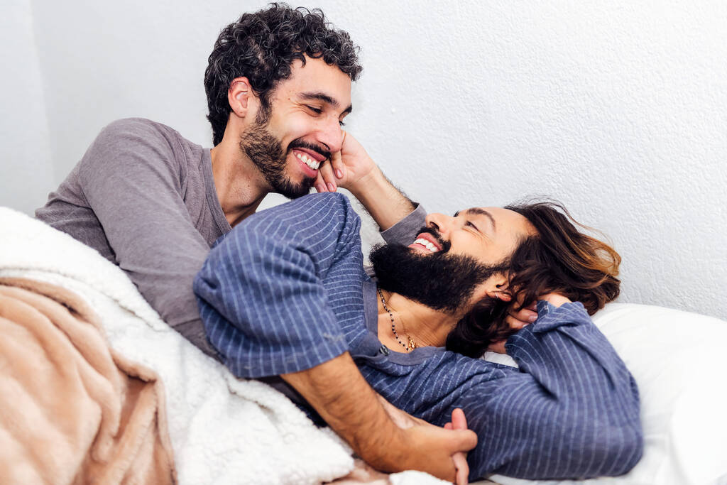 Homosexuell männliches Paar im Bett lächelnd glücklich, morgens gemeinsam aufzuwachen, Konzept des Lebensstils und der Liebe zwischen Menschen des gleichen Geschlechts - Foto, Bild