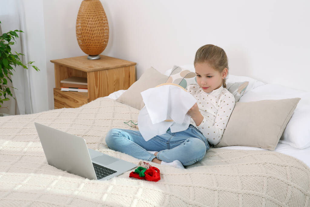 Bambina che impara a ricamare con il corso online a casa. Spazio per testo - Foto, immagini