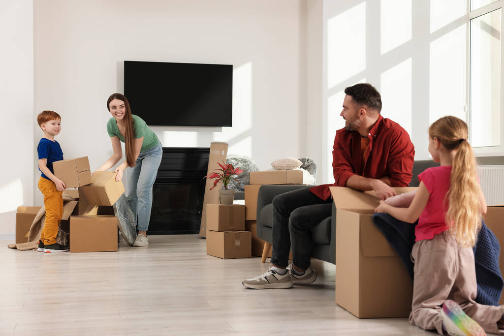 Joyeux famille déballer des boîtes dans un nouvel appartement. Jour de déménagement - Photo, image