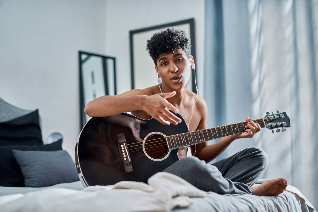 Chcete slyšet můj soundtrack z 2020. mladý muž hrající na kytaru ve své ložnici doma - Fotografie, Obrázek