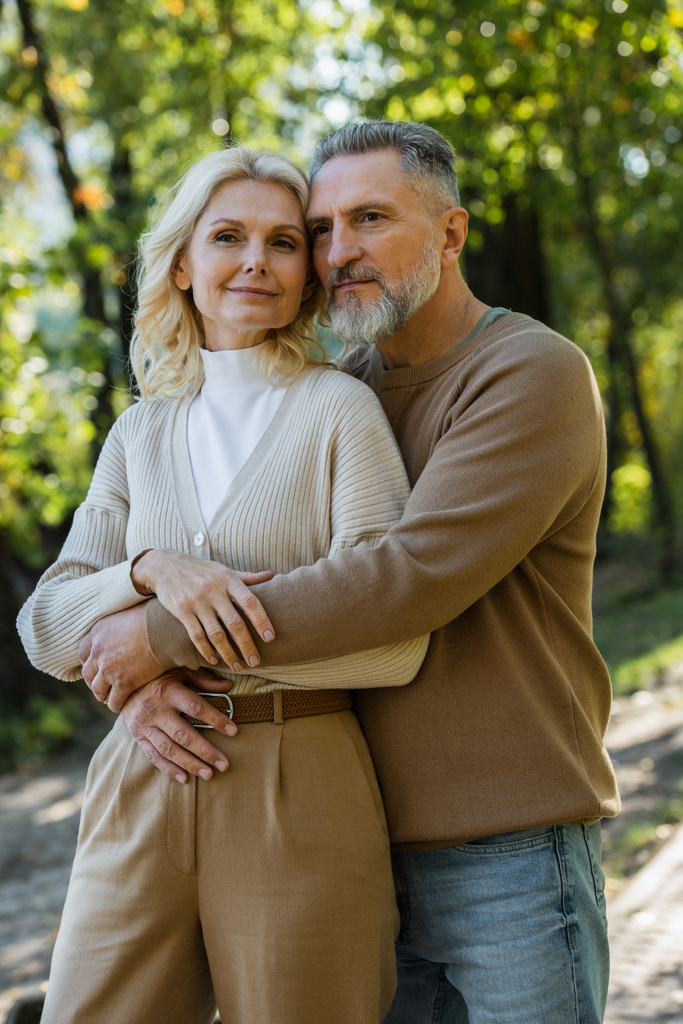 vousatý muž středního věku objímání okouzlující blondýny manželka v parku  - Fotografie, Obrázek