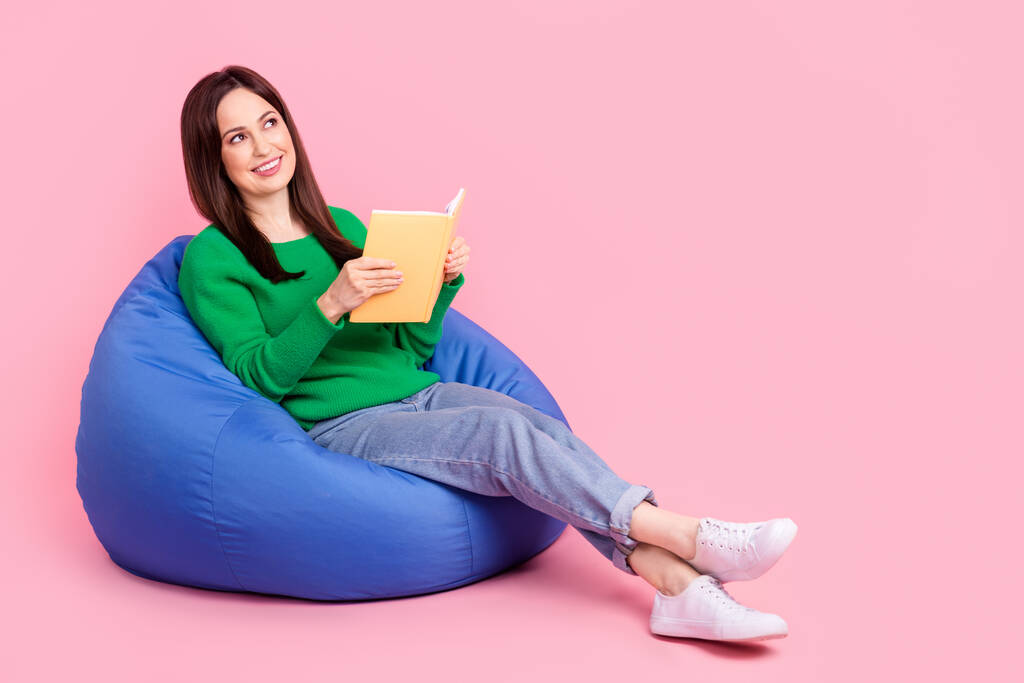 Retrato em tamanho completo de mente criativa menina sentar saco acolhedor ler livro olhar espaço vazio isolado no fundo cor-de-rosa. - Foto, Imagem