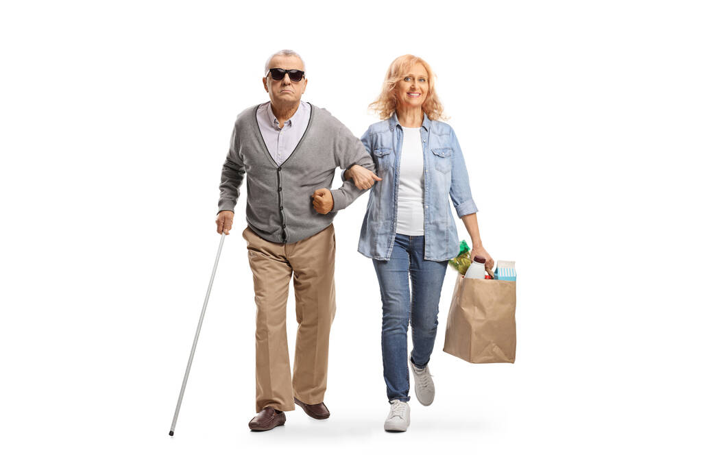 Frau hilft einem blinden älteren Mann mit Einkaufstaschen auf weißem Hintergrund - Foto, Bild