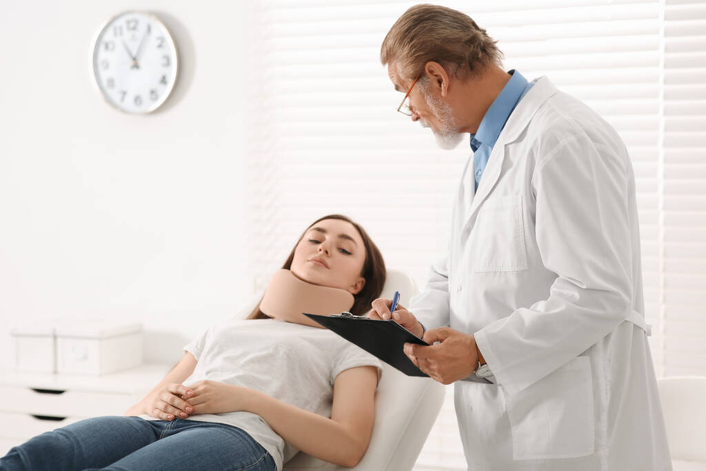 Ортопед осматривает пациента с поврежденной шеей в клинике - Фото, изображение