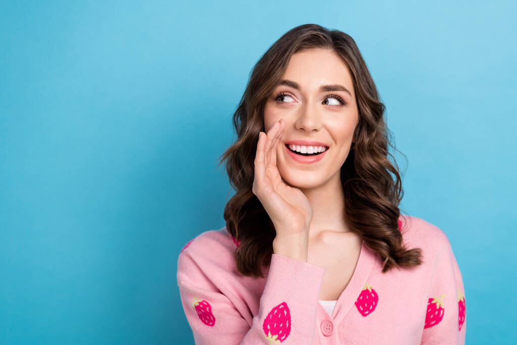 Photo of tricky dreamy woman wear pink cardigan arm mouth looking emtpy space isolated blue color background. - Photo, Image