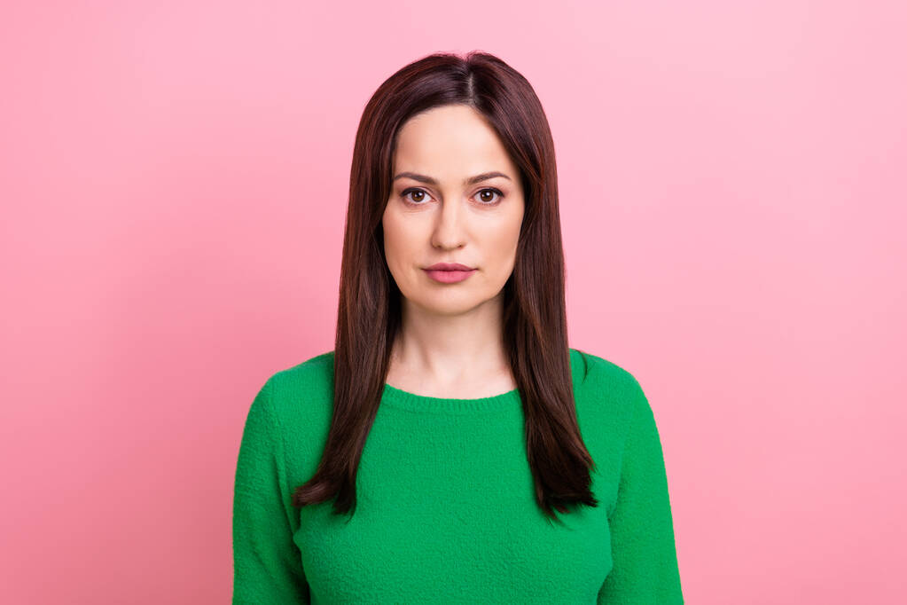 Фото серьезной уверенной женщины носить зеленый свитер глядя вы изолированы розовый цвет фона. - Фото, изображение