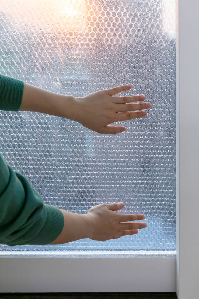 DIY Innenhandbewegung, Nahaufnahme _ Aufsetzen einer Luftkappe auf das Fenster - Foto, Bild