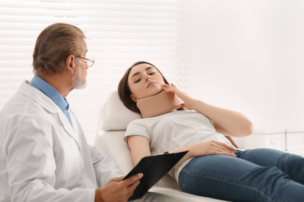 Orthopédiste examinant le patient avec un cou blessé en clinique - Photo, image