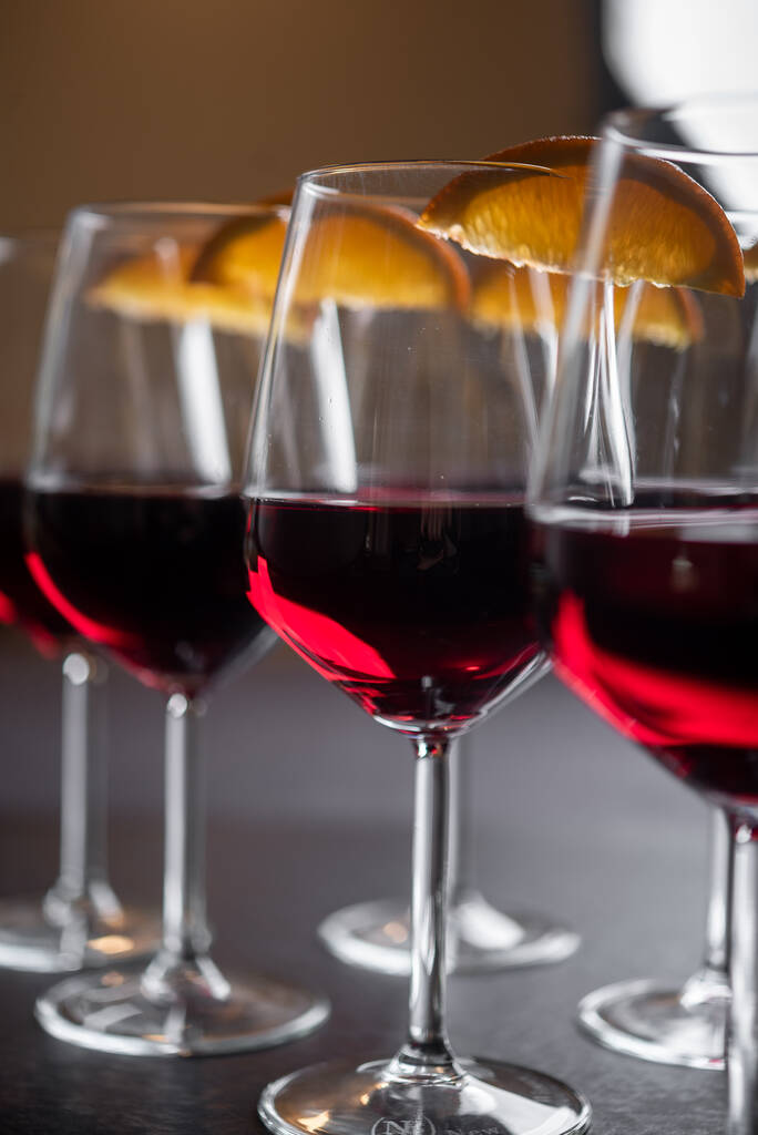 Vin rouge servi dans des verres avec des quartiers d'orange - Photo, image