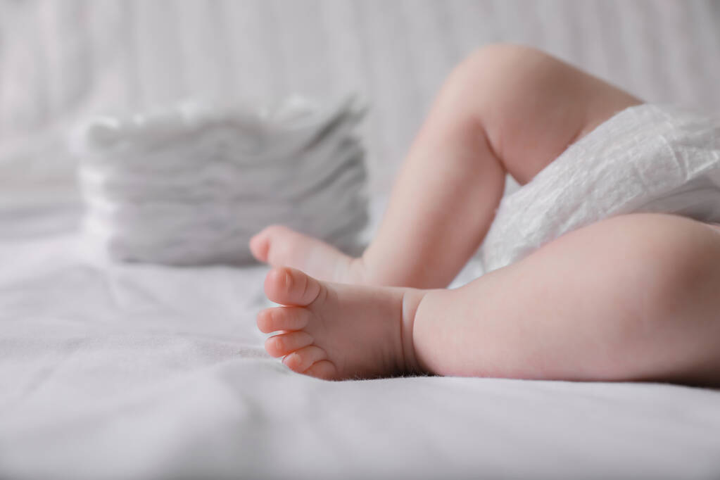 Pequeno bebê em fralda deitado na cama, close-up - Foto, Imagem