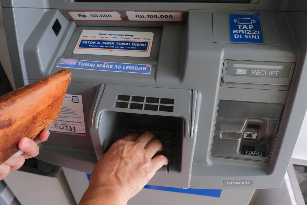 ręce ze skórzanym portfelem, pobranie gotówki z bankomatu w Yogyakarcie, 5 lutego 2023 r. - Zdjęcie, obraz