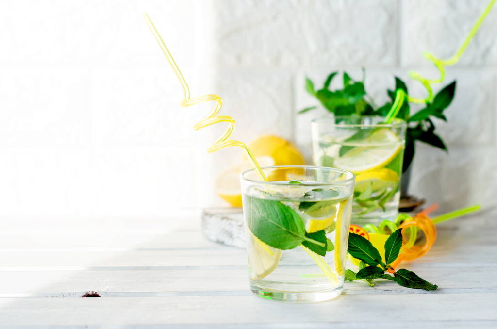 モヒートカクテルグラスレモンミントの葉バスケットに白木のテーブルカクテル夏の飲み物のコンセプト - 写真・画像