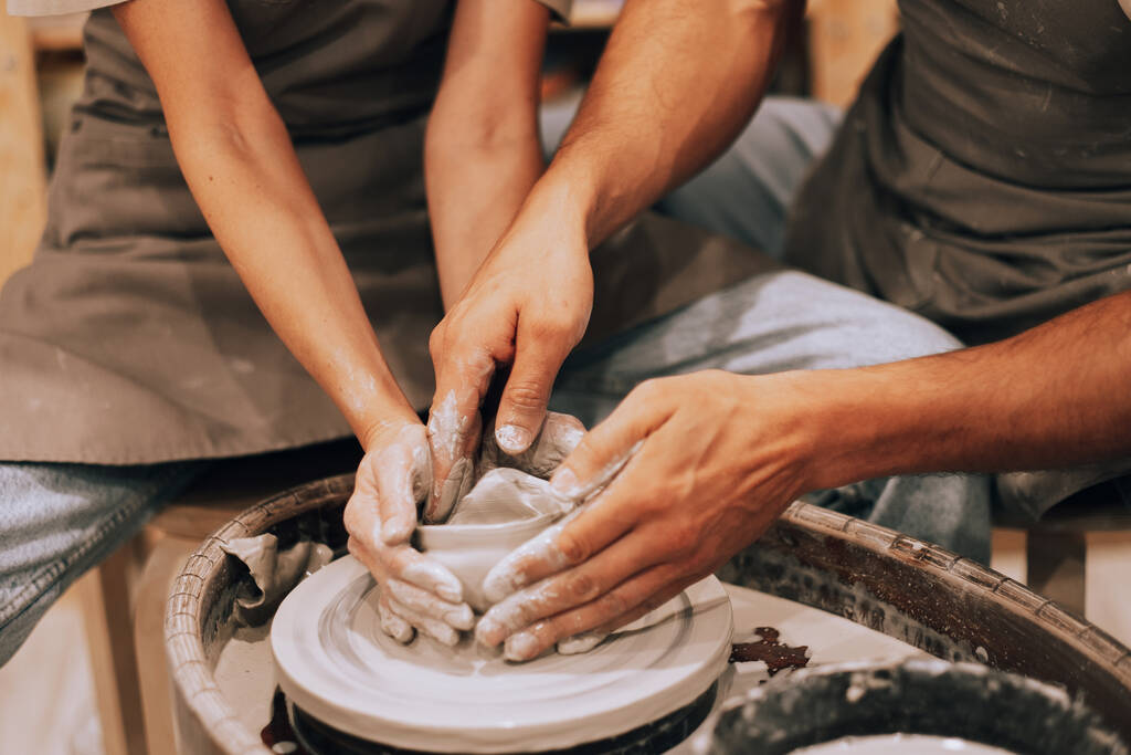 Jarrón de cerámica de molde de par en un taller de cerámica, las manos se cierran. El concepto de aficiones, estilo de vida y relaciones. - Foto, Imagen