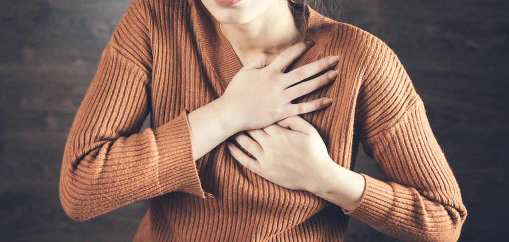 γυναίκα χέρι σε πονεμένη καρδιά σε σκούρο φόντο - Φωτογραφία, εικόνα