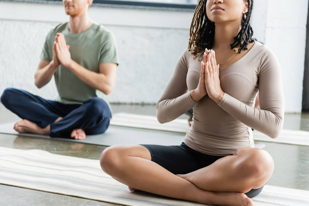 Vista recortada de una mujer afroamericana practicando anjali mudra en clase de yoga  - Foto, imagen