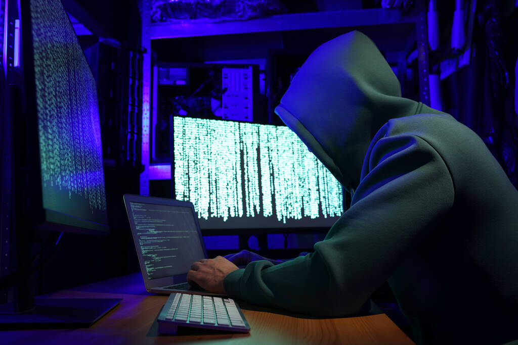 Haker pracujący z komputerami w ciemnym pokoju. Cyberatak - Zdjęcie, obraz