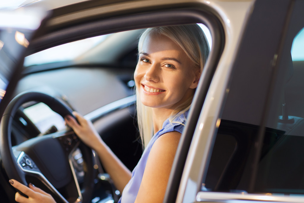Ευτυχισμένη γυναίκα μέσα στο αυτοκίνητο σε έκθεση αυτοκινήτων ή σαλόνι - Φωτογραφία, εικόνα