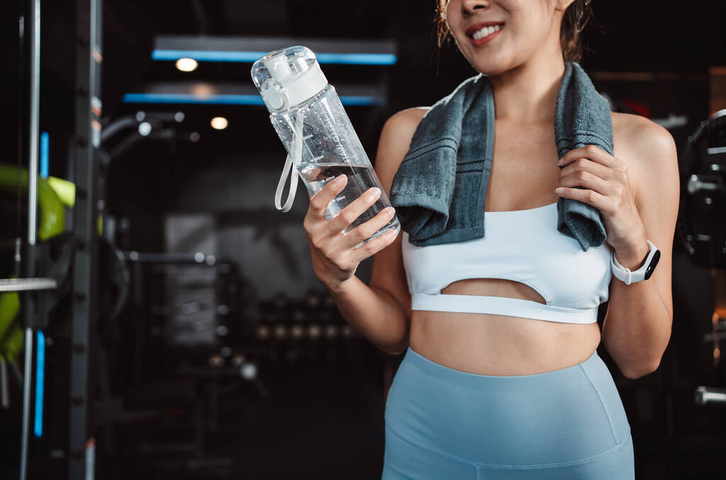 Nő ivóvíz-helyreállítási egészségügyi edzés tornaterem fitness törés pihenés edzés után sport vízforraló, súlyzó és vizes palack egészséges életmód testépítés. - Fotó, kép
