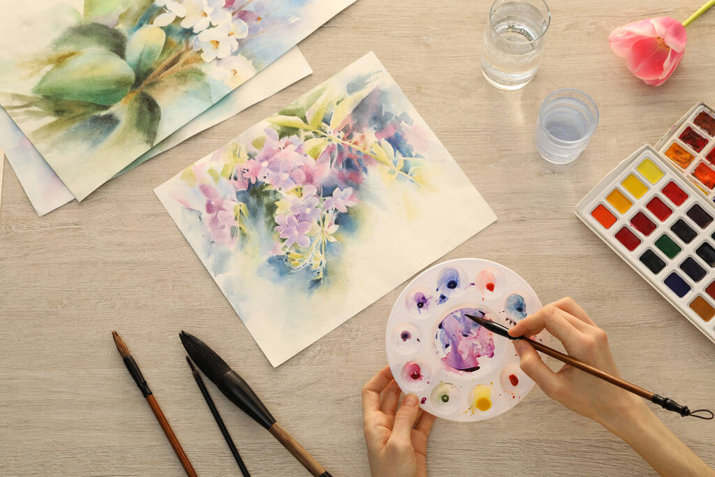 Nainen maalaus kukkia vesiväri valkoinen puinen pöytä, ylhäältä näkymä. Luova taideteos - Valokuva, kuva