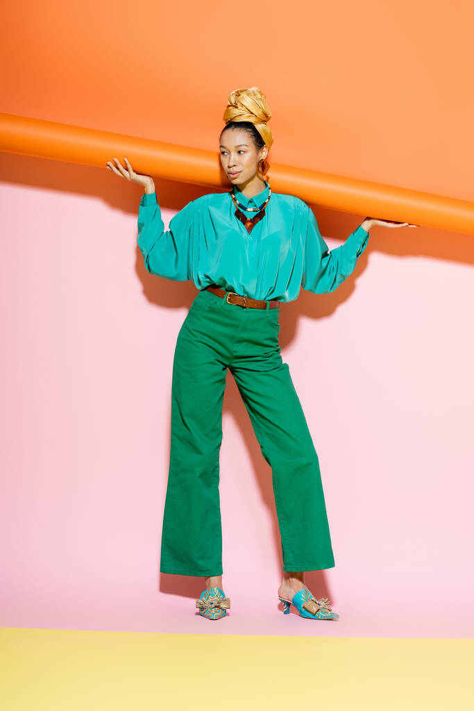 Полная длина модной африканской американки в летней одежде позирует на красочном фоне  - Фото, изображение