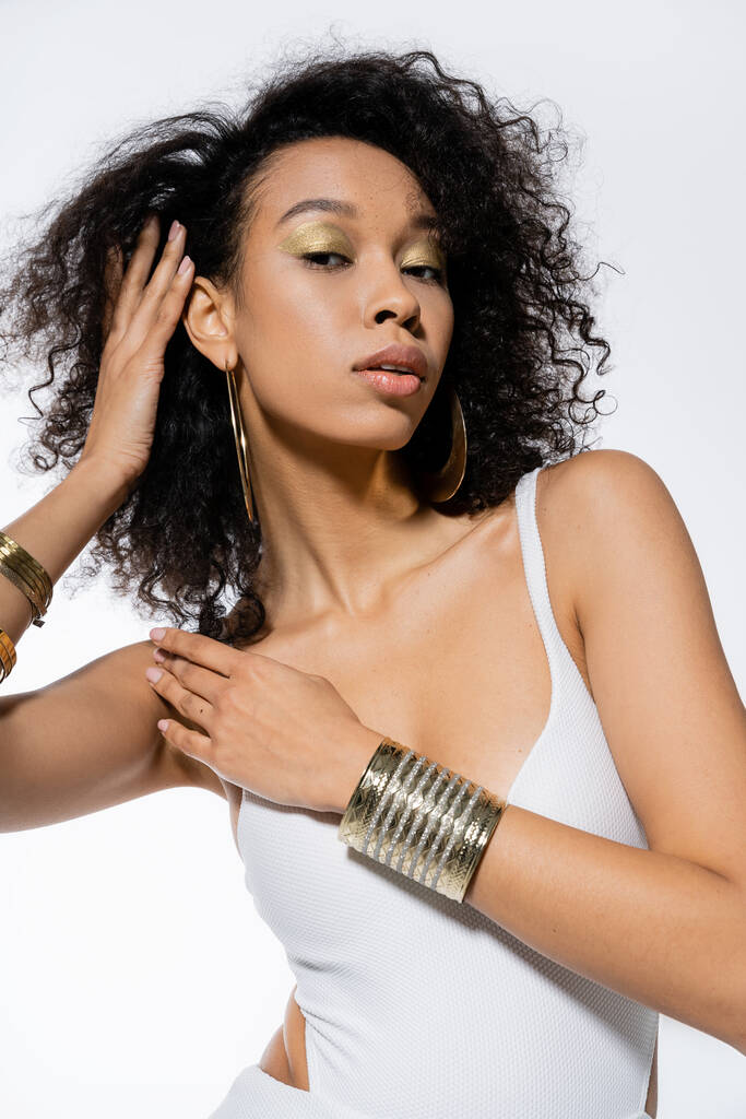 Giyinik ve aksesuarlı modacı Afro-Amerikan modeli gri renkli kameraya bakıyor.  - Fotoğraf, Görsel
