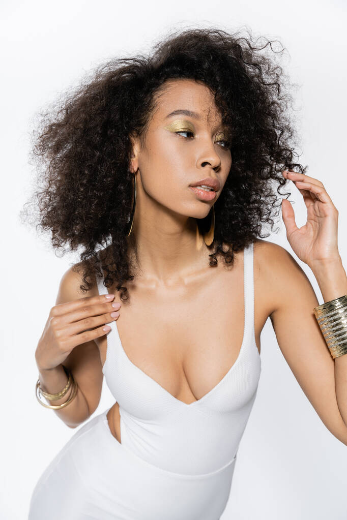 krullend Afrikaans Amerikaans model in badpak poseren geïsoleerd op wit  - Foto, afbeelding