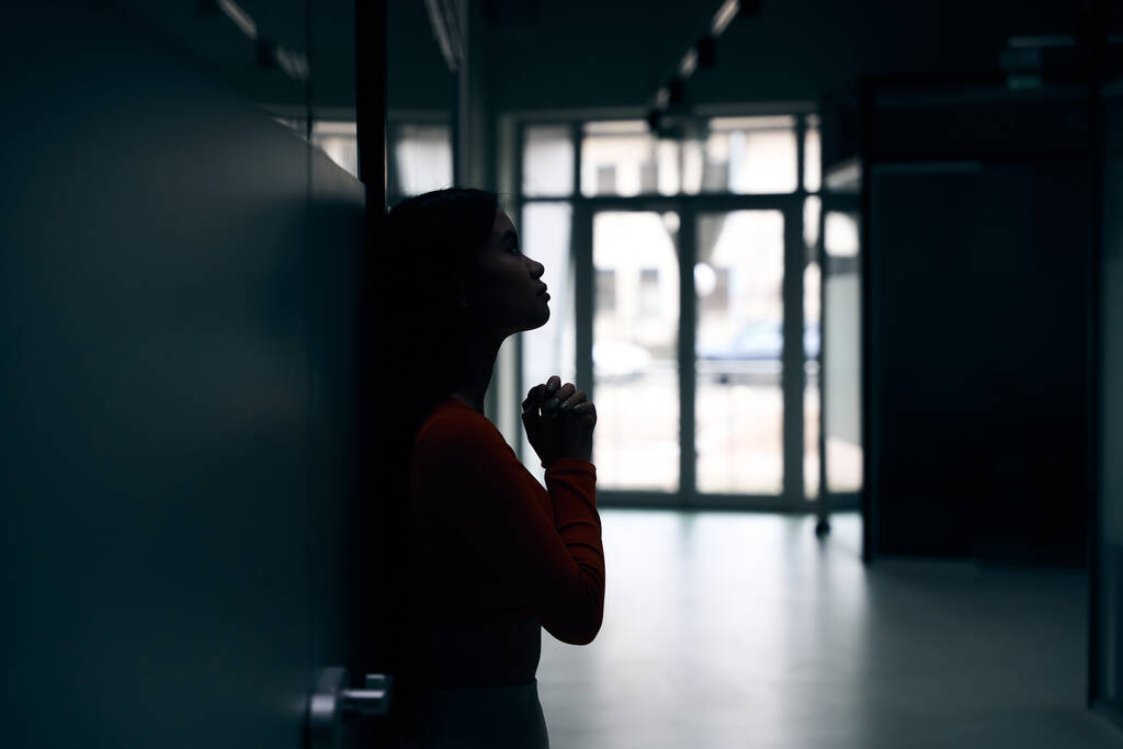 Sivunäkymä surullinen nuori naispuolinen yritystyöntekijä tarttui kädet nojaten seinää vasten - Valokuva, kuva