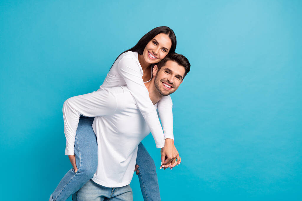 Профиль фото двух идиллических положительных партнеров piggyback охватывают пустое пространство, изолированное на синем фоне цвета. - Фото, изображение