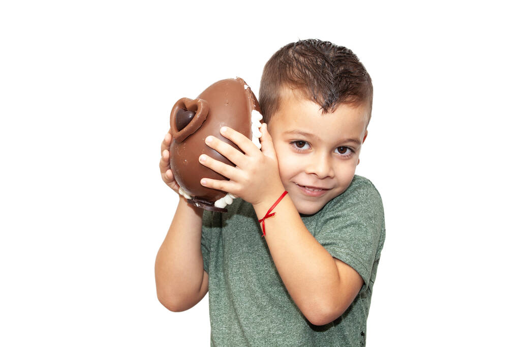 szczęśliwy chłopczyk z wielkanocnym czekoladowym jajkiem na jasnym tle - Zdjęcie, obraz