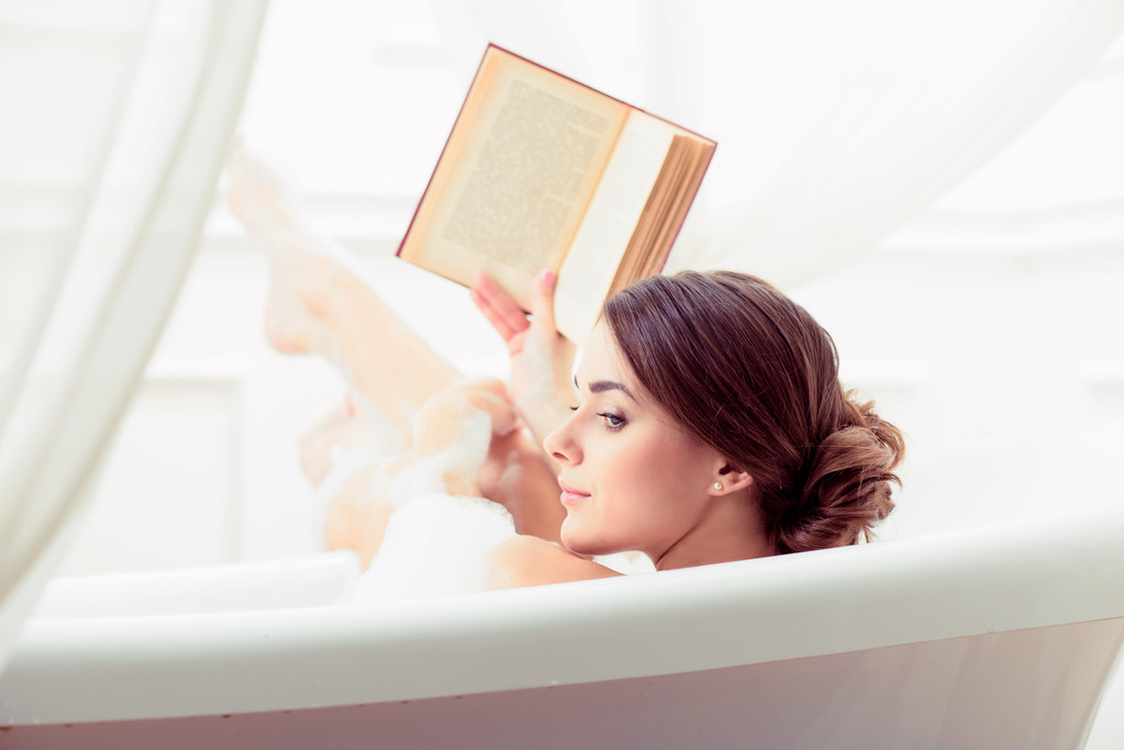 Hermosa joven en el baño con un libro
 - Foto, imagen