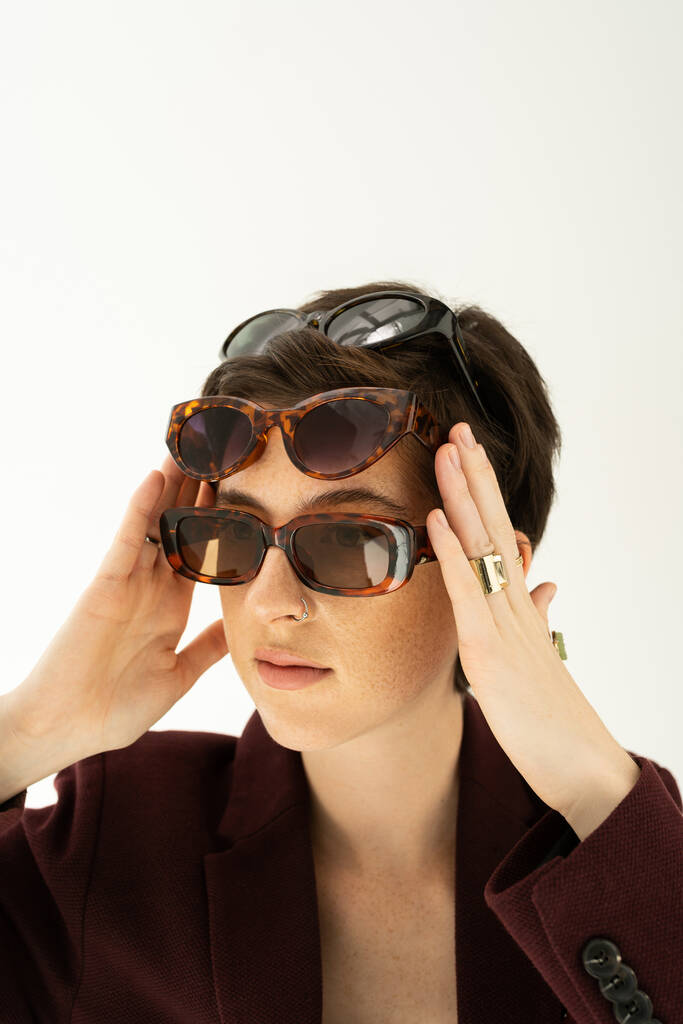  πορτρέτο της trendy γυναίκα φορώντας διαφορετικά μοντέρνα γυαλιά ηλίου απομονώνονται σε γκρι - Φωτογραφία, εικόνα