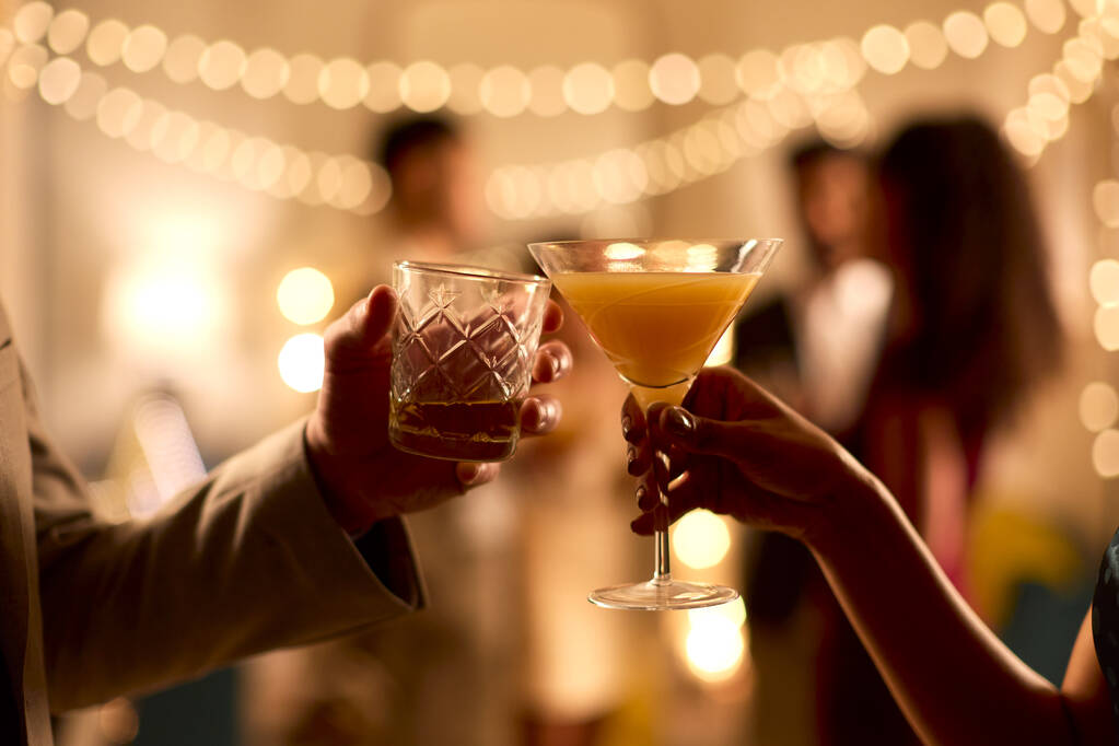 Close-up de casal na festa fazendo um brinde com bebidas juntos - Foto, Imagem