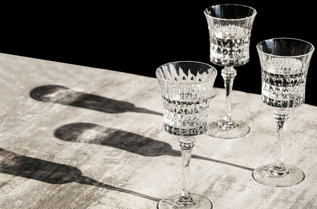 ハードライトと長い影、ワインテストのコンセプト、モノクロとグレーの背景に白ワインと2つの結晶ワイングラス。レストランでのデグストレーションブランチ、テキストのためのスペースのコピー - 写真・画像