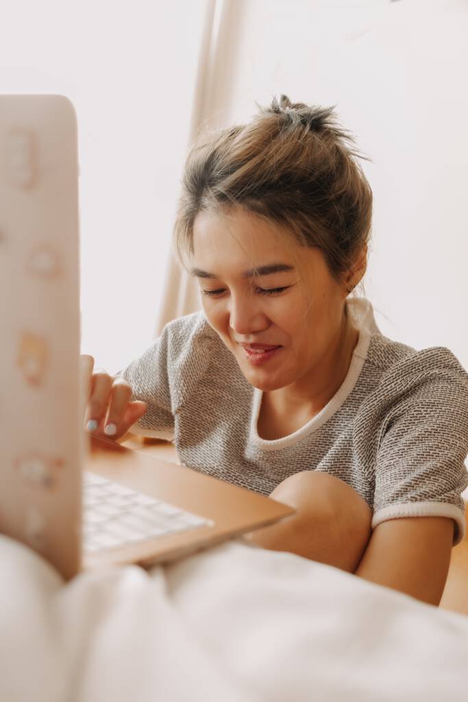 Sorriso feliz mulher asiática trabalho em seu computador em seu quarto. - Foto, Imagem