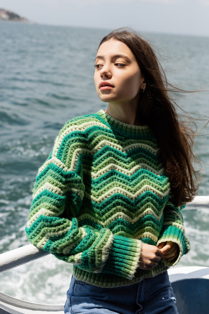 若いです女性でニットセーターに立ってフェリーボートで海とバックグラウンドでトルコ  - 写真・画像