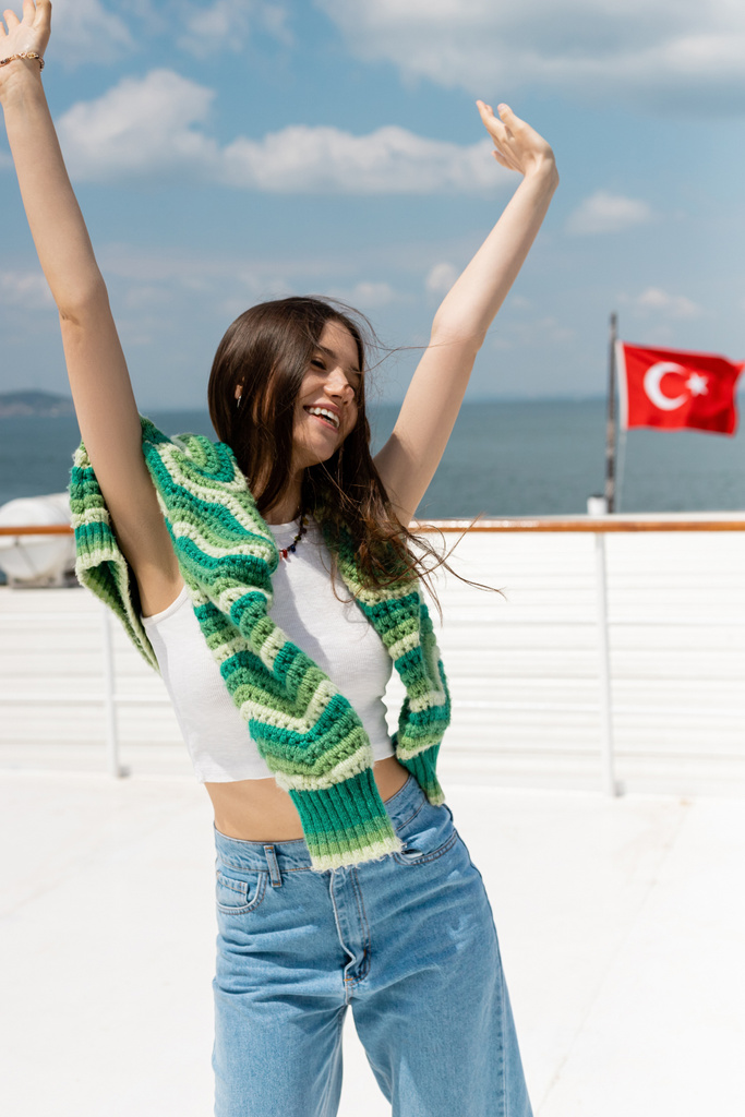 Gondtalan fiatal turista felemeli a kezét hajókirándulás közben Törökországban  - Fotó, kép