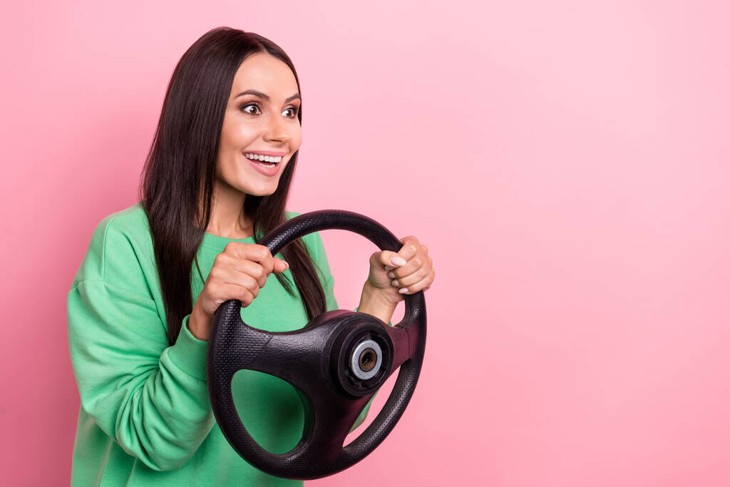 Gros plan photo de jeune pilote dame brune tenue de cheveux volant usure chemise verte excité vitesse automobile isolé sur fond de couleur rose. - Photo, image