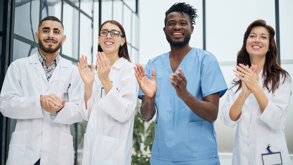 Équipe réussie de différents médecins applaudissant les mains à l'hôpital - Photo, image