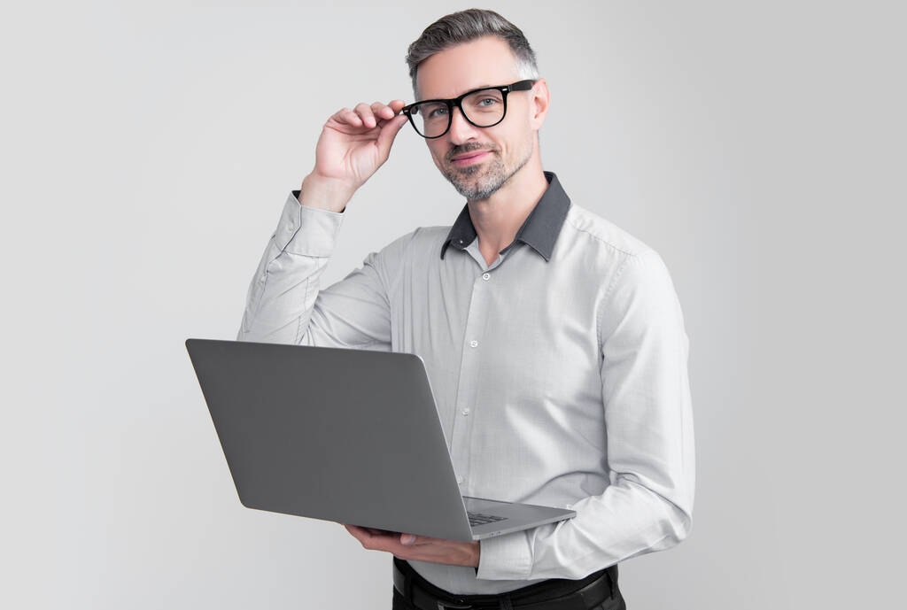 mature entrepreneur in eyeglasses working on computer on grey background. - Valokuva, kuva