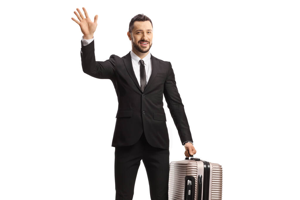 白い背景に隔離されたカメラで手を振るスーツケースを持つ男性の乗客 - 写真・画像