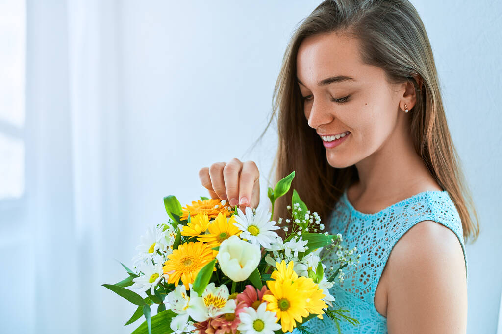 Piękny szczęśliwy młoda uśmiechnięta kobieta z dekoracyjnym kolorowe jasne świeże pudełko kapelusz kwiat na wakacje wiosna dzień kobiet  - Zdjęcie, obraz