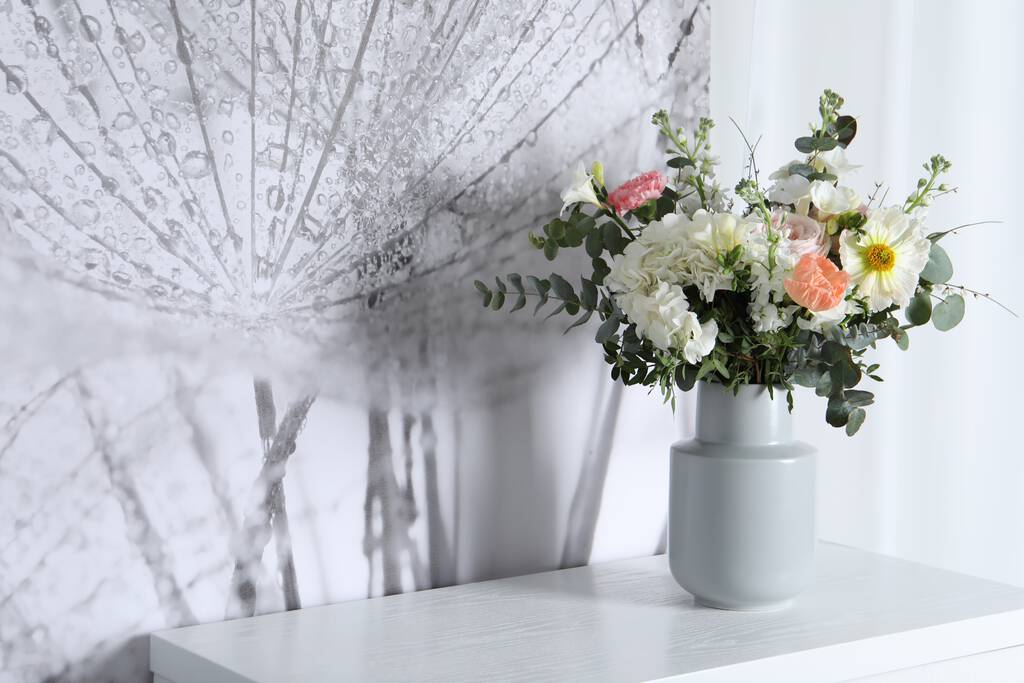 Bouquet with beautiful flowers on white chest of drawers indoors. Space for text - Photo, Image