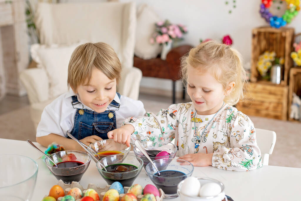 Happy childen, rodzeństwo, kolorowanki z kolorowymi wodami na Wielkanoc w domu, słoneczny pokój - Zdjęcie, obraz