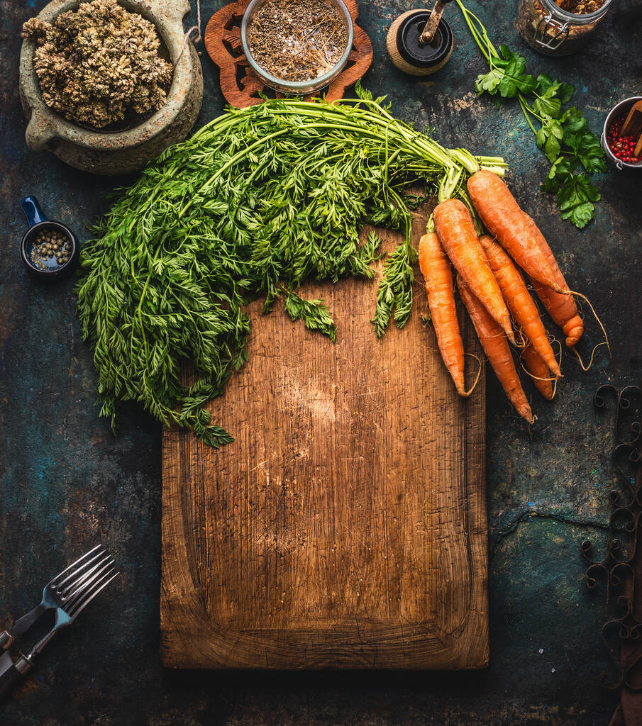 Fondo alimentare rustico con mazzo di carote con verdure sul tagliere. Vista dall'alto. Cornice. Cucina casalinga sana. Cucina casalinga - Foto, immagini